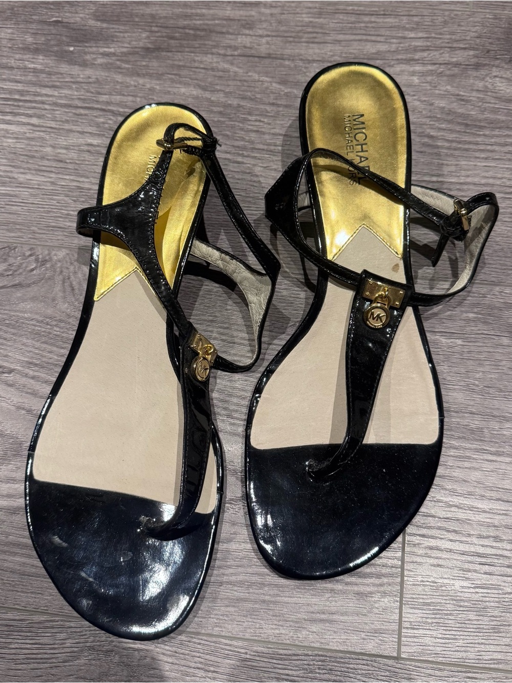 MICHAEL Michael Kors Black Patent T-Strap Sandals with Gold Accents